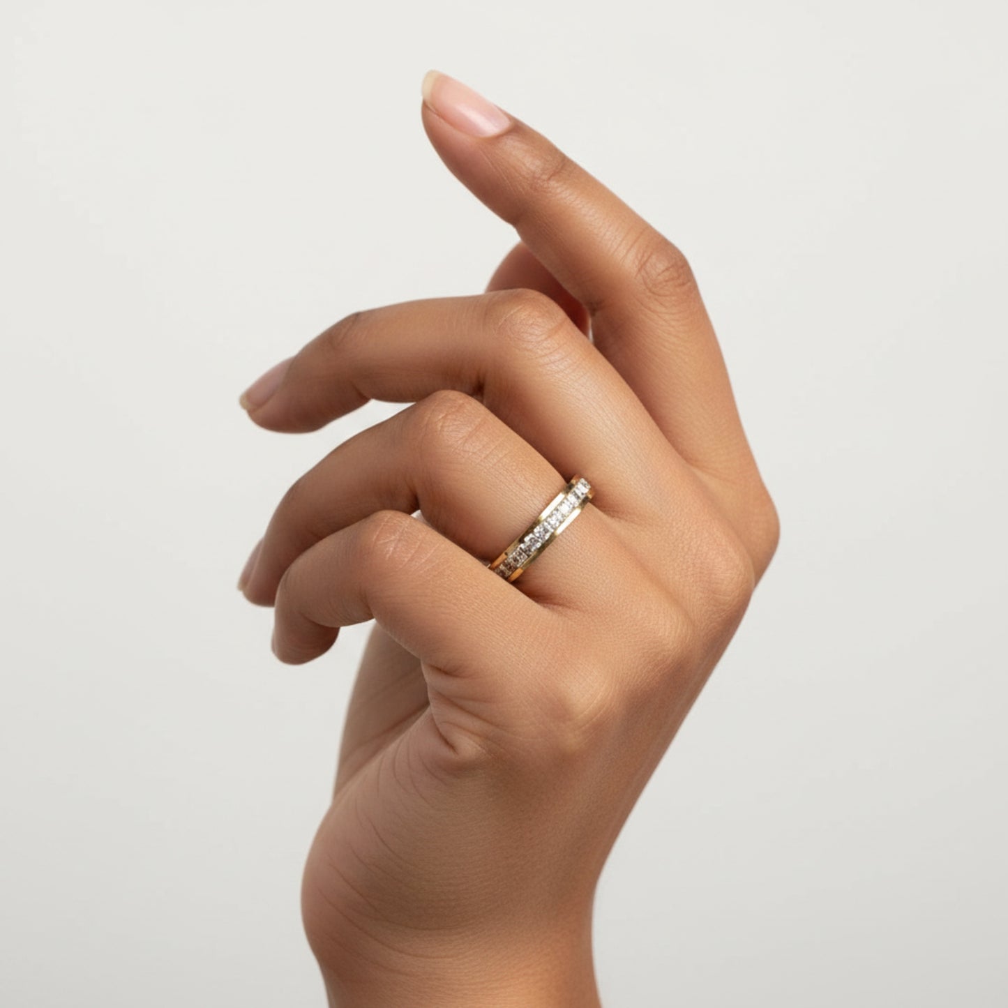 Model wearing a crystal pavé half eternity band ring on a polished gold-tone band