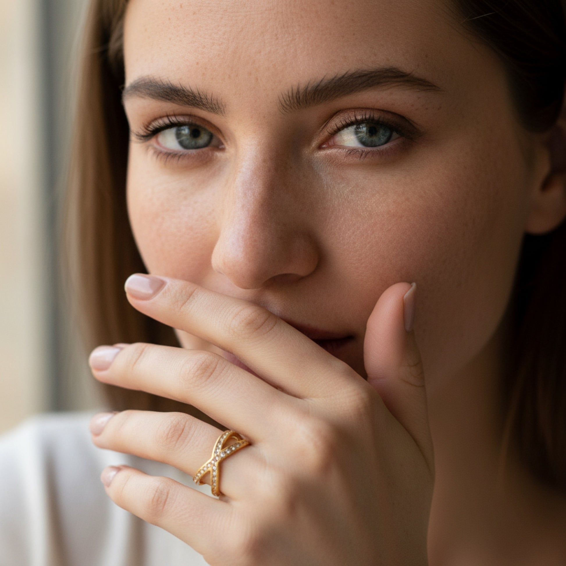 Model wearing a crystal pavé crossover double band ring in gold-tone finish